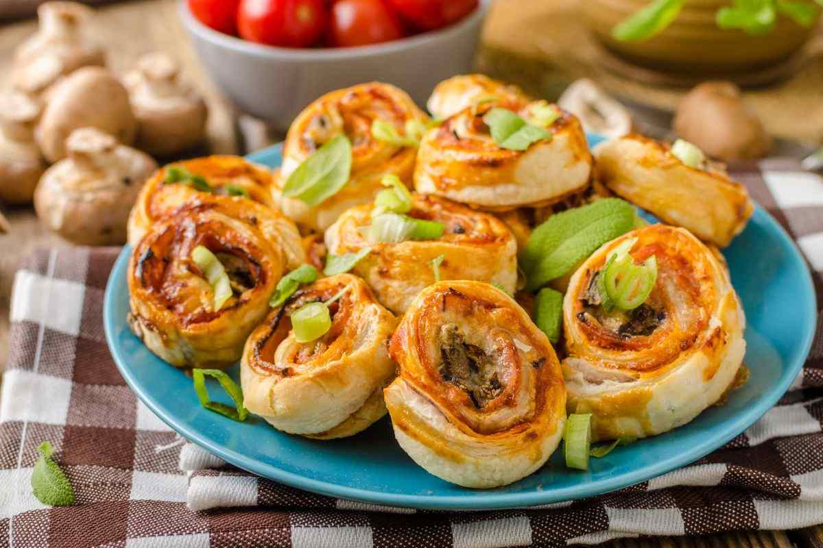 piatto con rotolini di sfoglia, funghi e pomodori