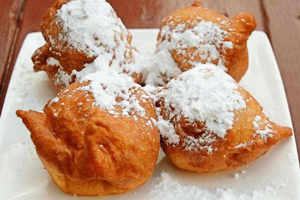 Fritole veneziane su un piatto con tanto zucchero a velo