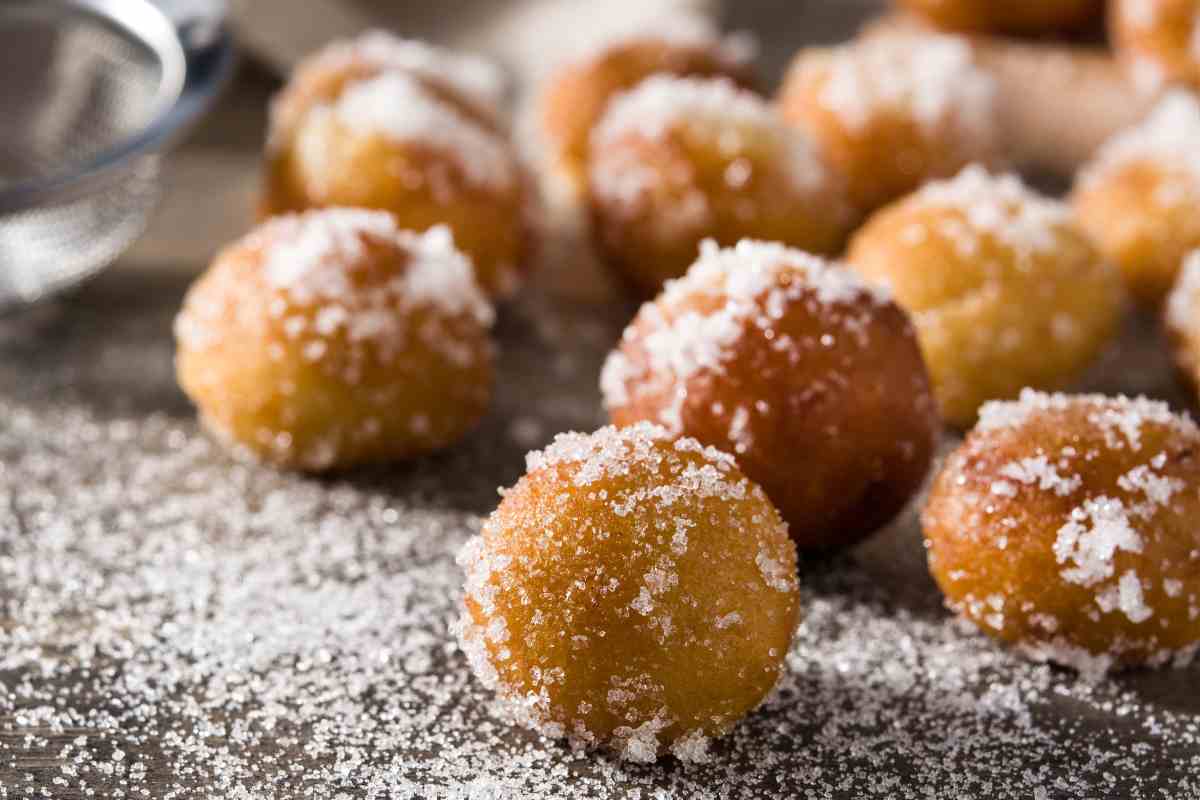 Frittelle di riso cosparse di zucchero su un piano di lavoro