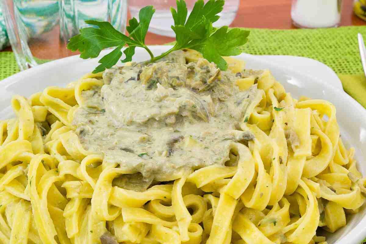 Piatto di tagliatelle con crema di carciofi e ciuffo di prezzemolo