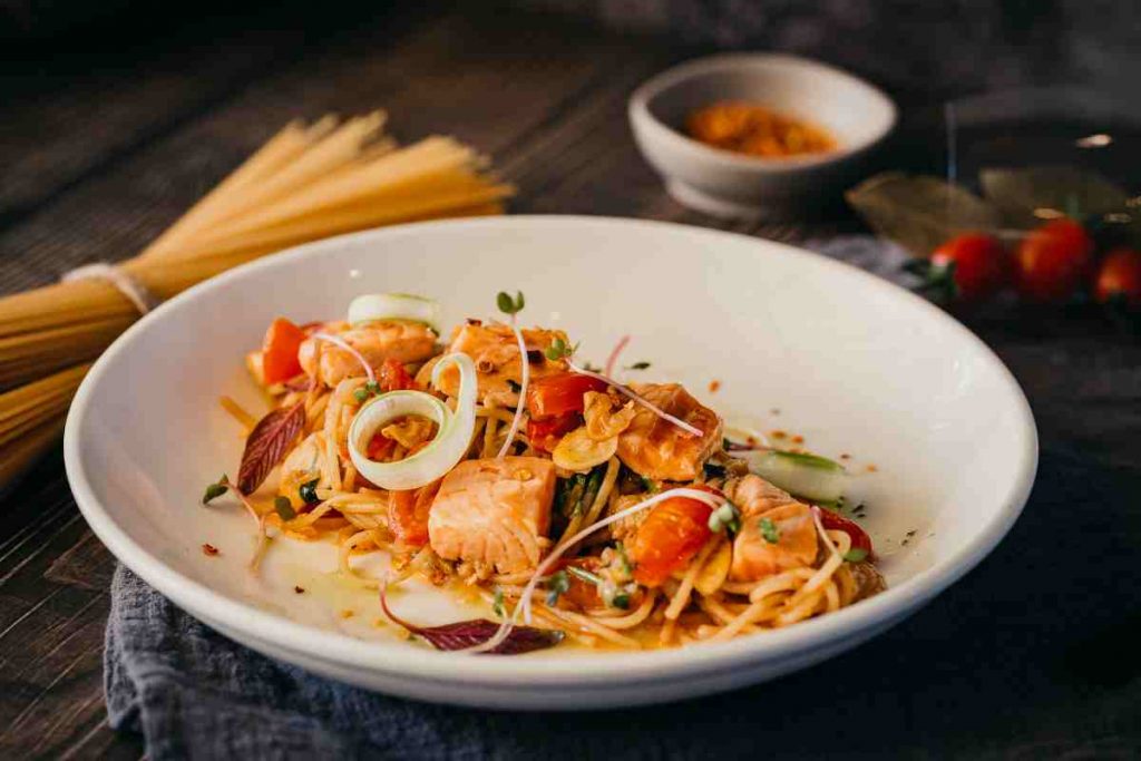 Spaghetti con salmone e pomodorini in un piatto