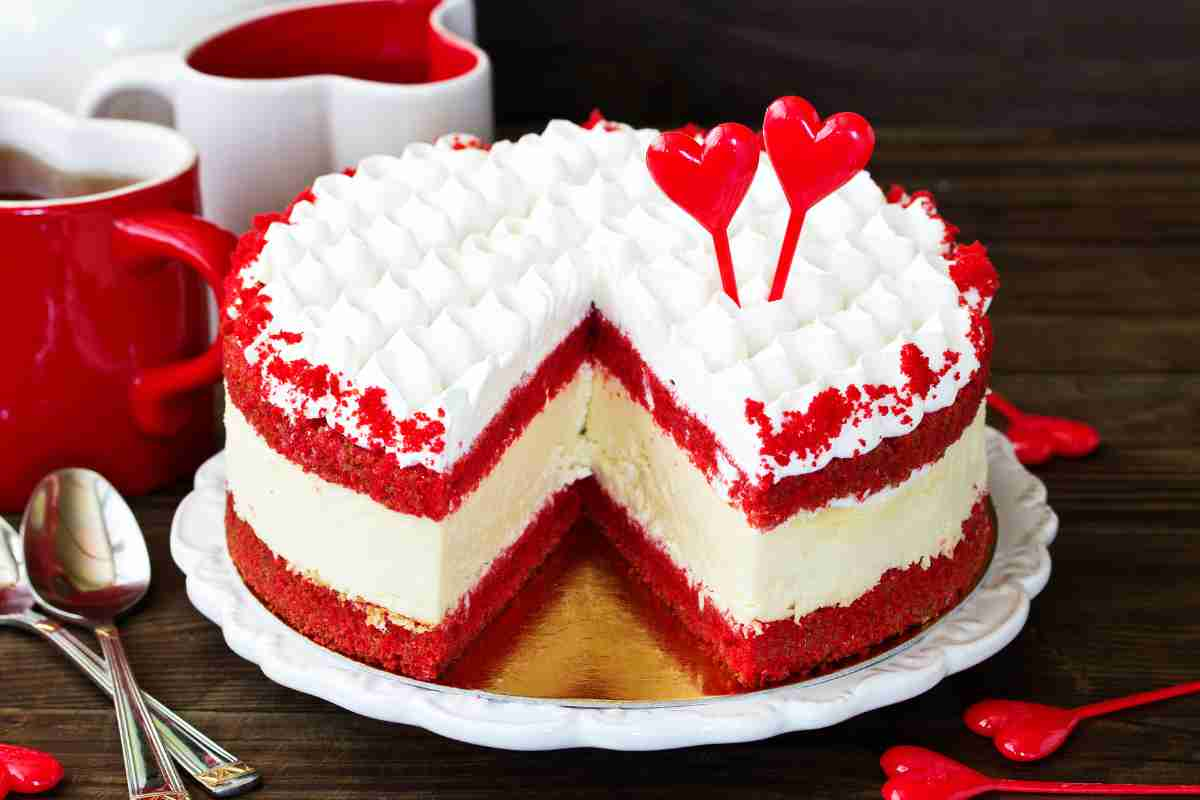 Torta red velvet con una detta mancante e decorazioni a forma di cuore