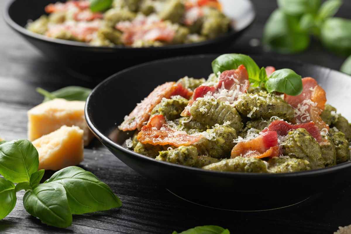 piatto di gnocchi con pancetta e pesto