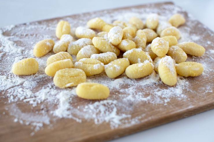 tagliere con gnocchi di patate crudi e farina 