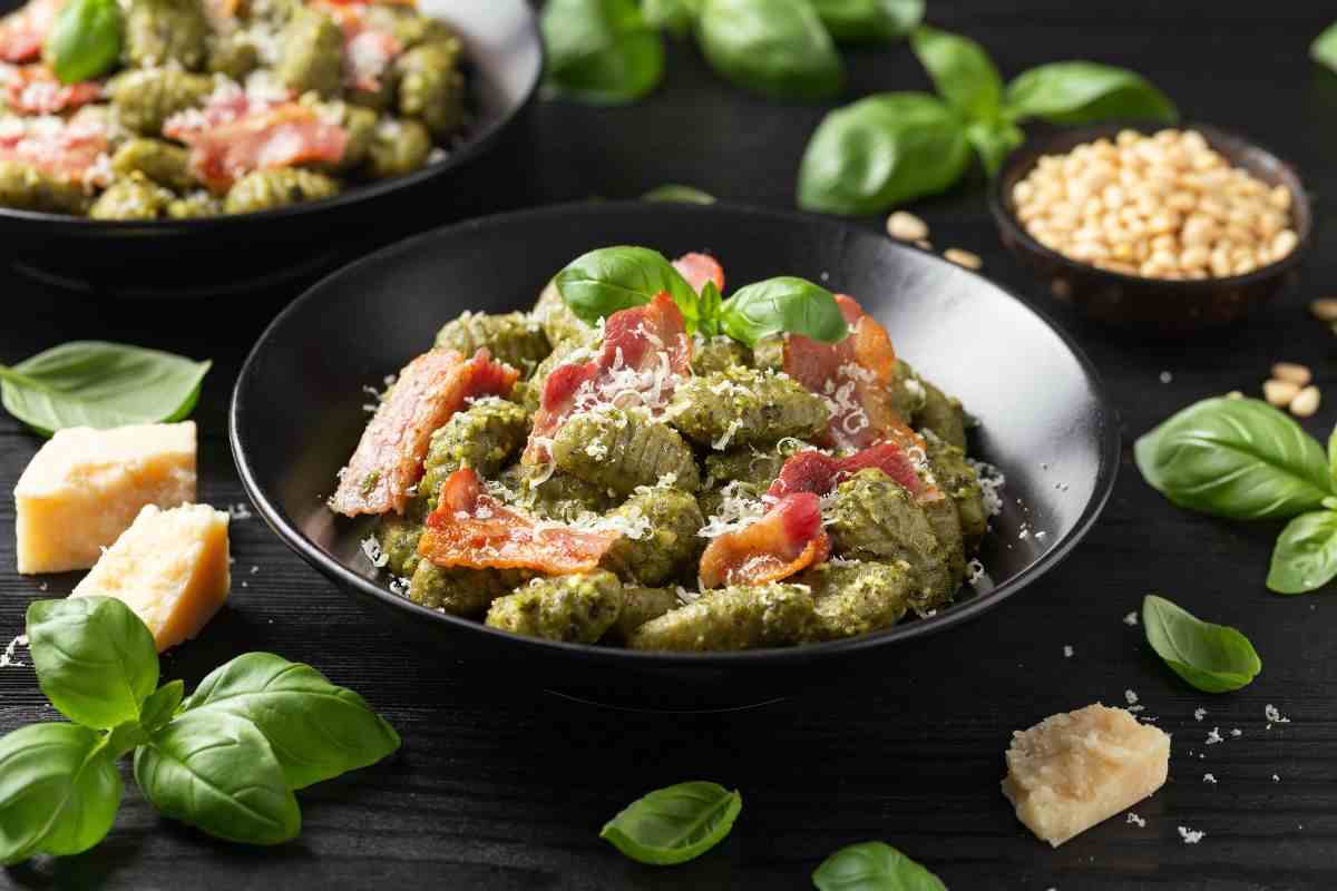 piatto di gnocchi al pesto con pancetta