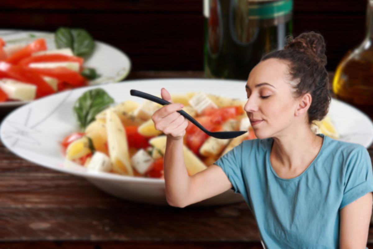 donna con mestolo e piatto di pasta con pomodori e mozzarella