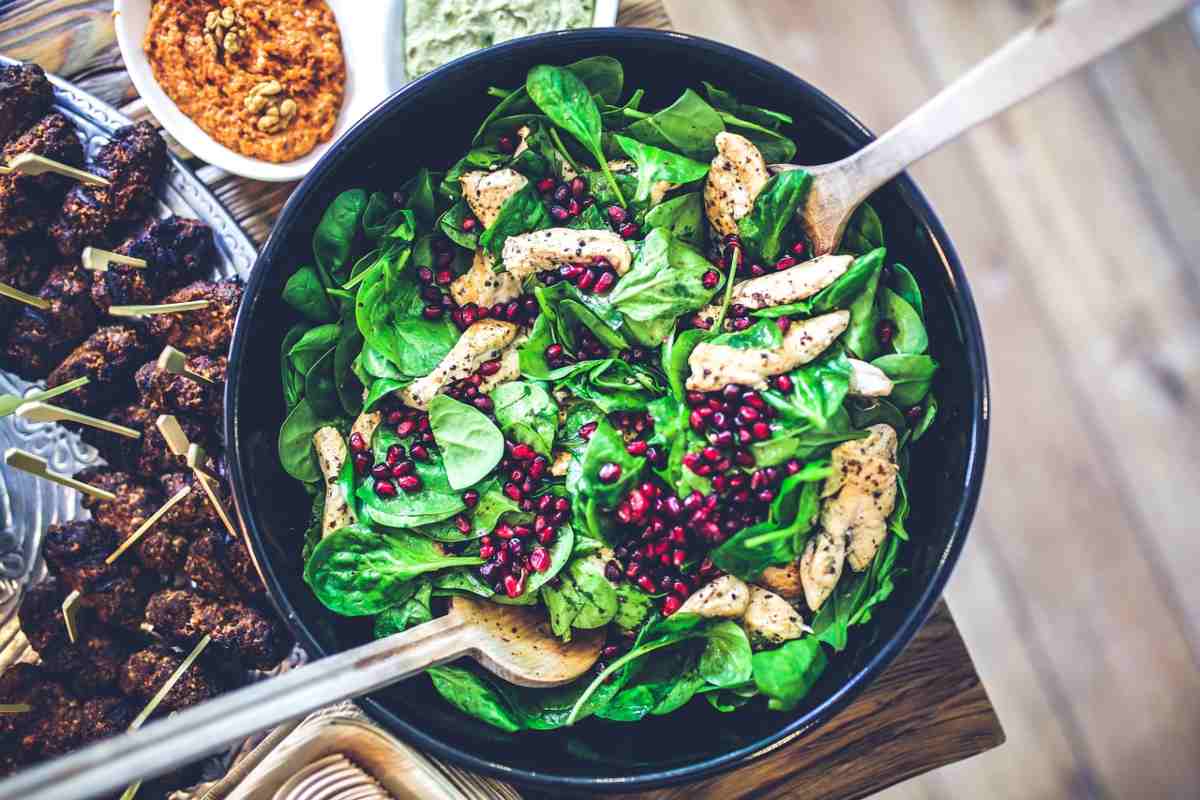 ciotola con insalata di pollo, spinaci e melograno