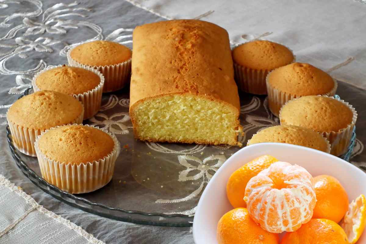 Muffin e dolce su un vassoio con una ciotola di mandarini