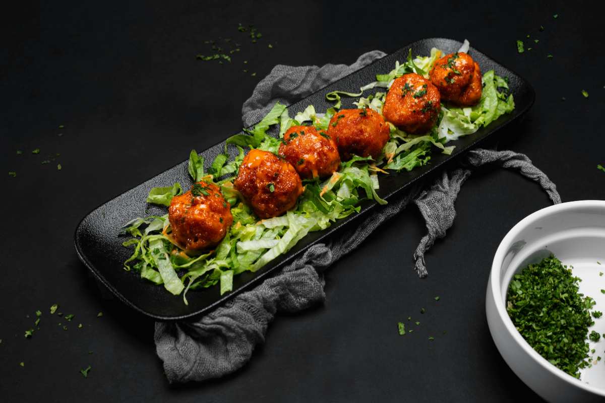 polpette al sugo sopra un letto di insalata verde