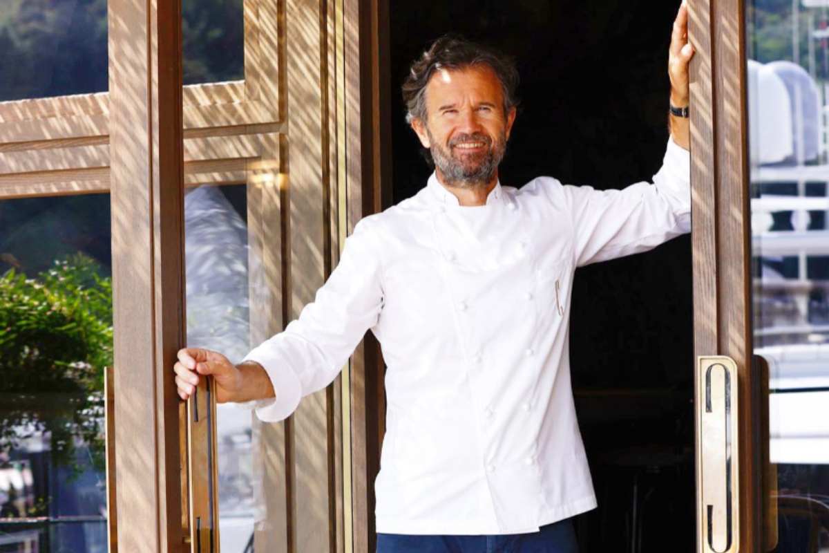 carlo cracco che sorride sulla porta del suo ristorante