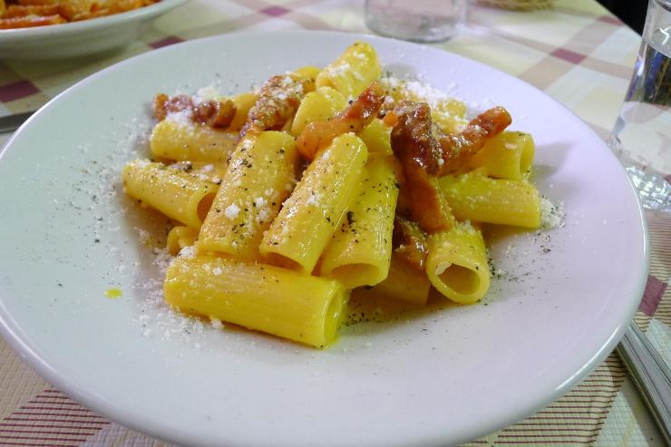 piatto di rigatoni alla carbonara con uovo guanciale formaggio grattugiato e pepe