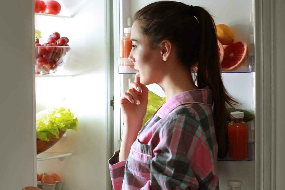 Ragazza guarda nel frigo