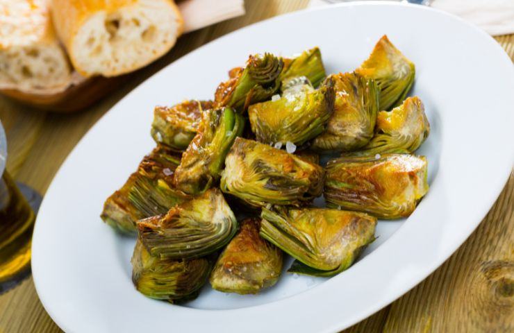 carciofi tagliati su un piatto bianco