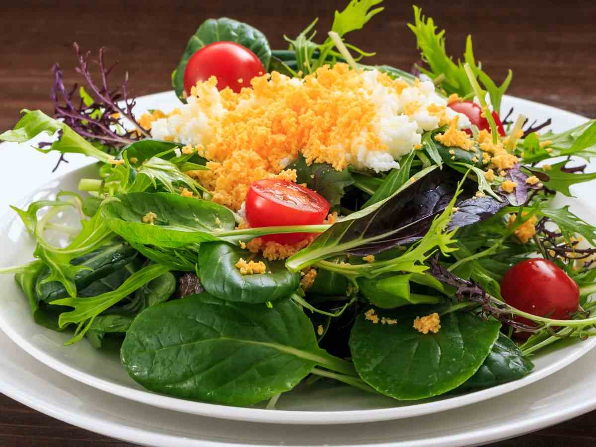 piatto di insalata con spinacino, pomodorini e altri ingredienti