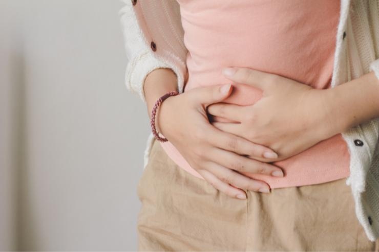 Busto di donna che ha le mani sulla pancia