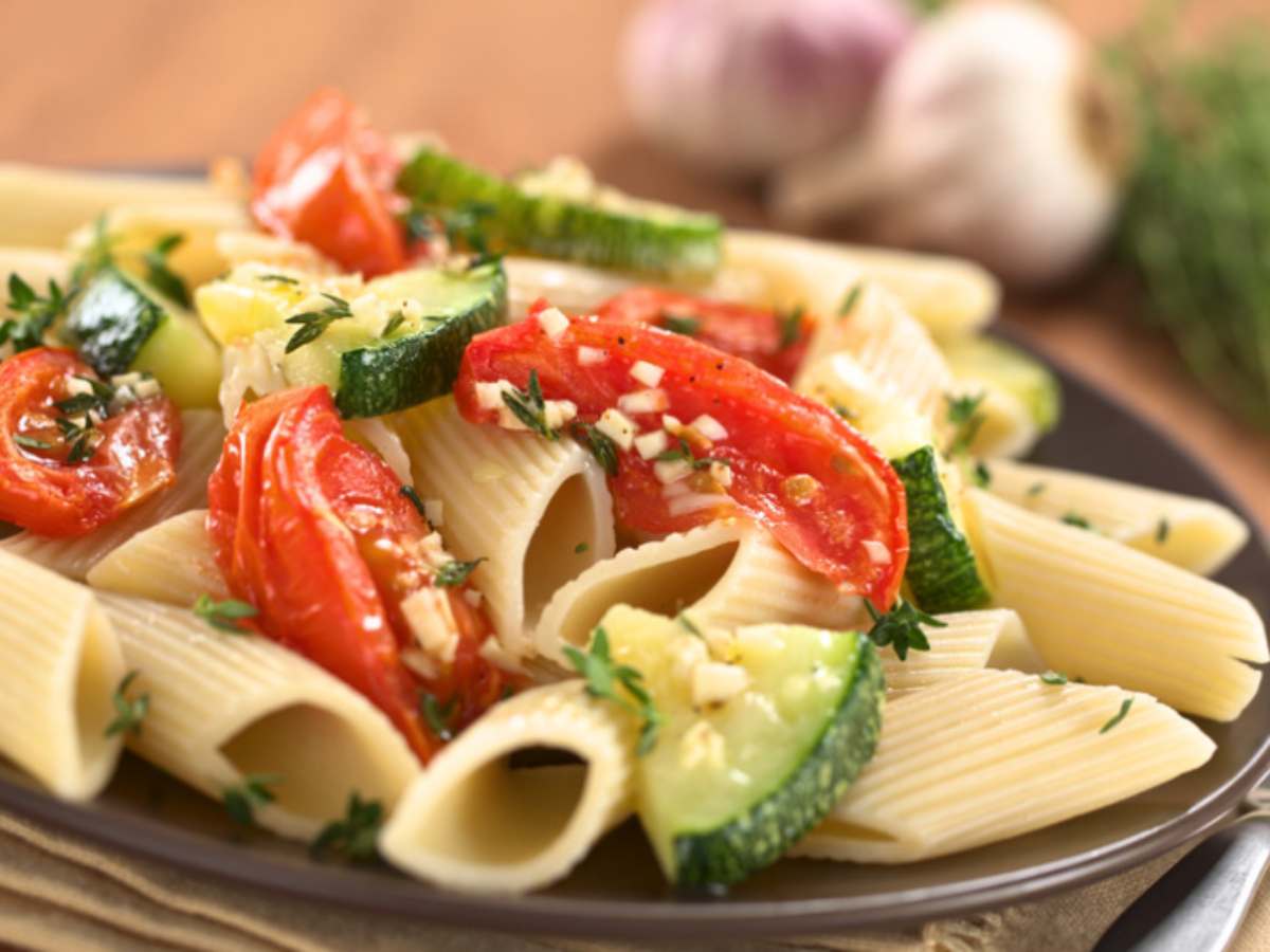 piatti di pasta con verdure e pomodori