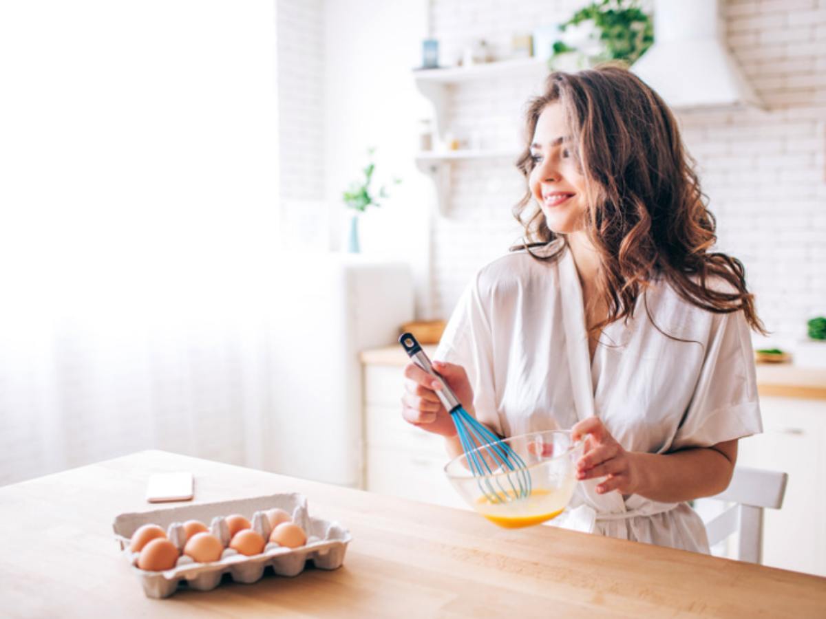 donna in cucina che sbatte le uova