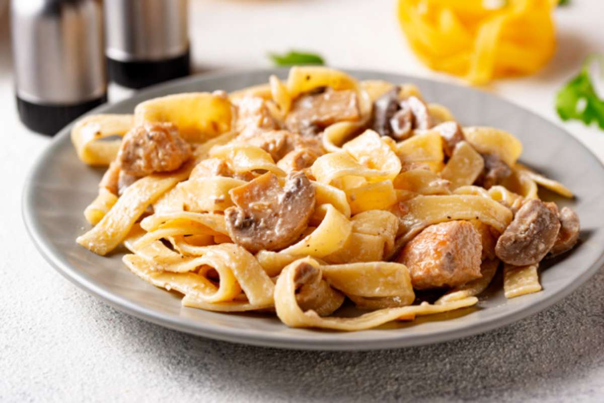 pasta con i funghi in piatto grigio