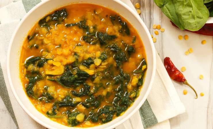 Piatto con zuppa di lenticchie e spinaci